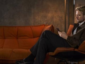 Mand i sofa med mobil