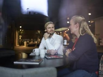 kvinde og mand ved bord taler