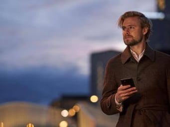 Mand med telefon udenfor