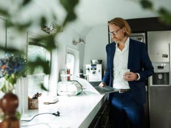 Mand med computer og en kop kaffe