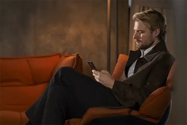 mand med telefon i hånden