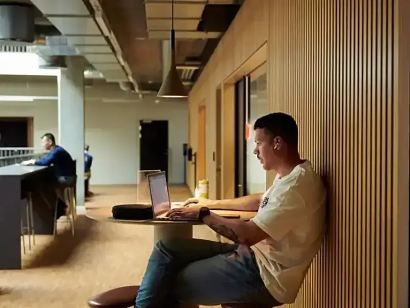 Person med compuer ved lille bord