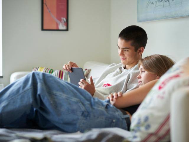 To personer på sofa kigger på ipad