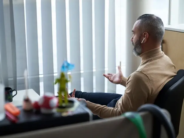 Person gestikulerer og taler i headset